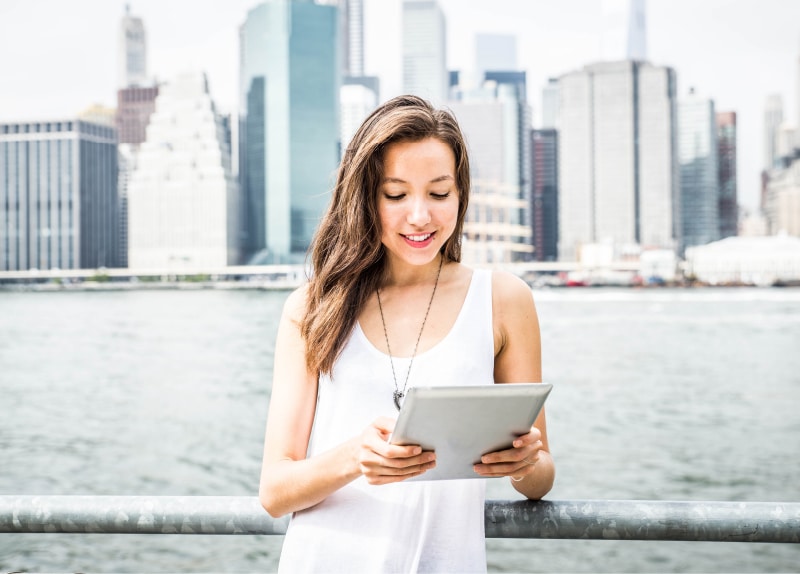 Woman looking at tablet with city background